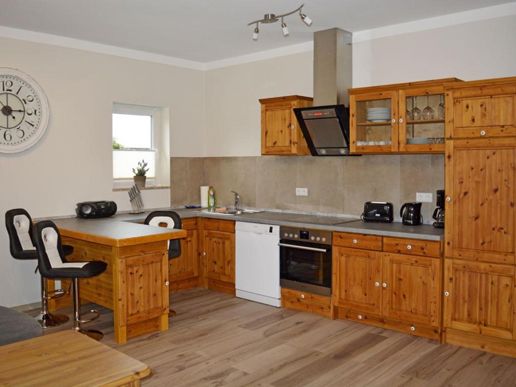 - une cuisine avec des placards en bois et un comptoir dans l'établissement Ferienwohnung Teltow 2, à Teltow