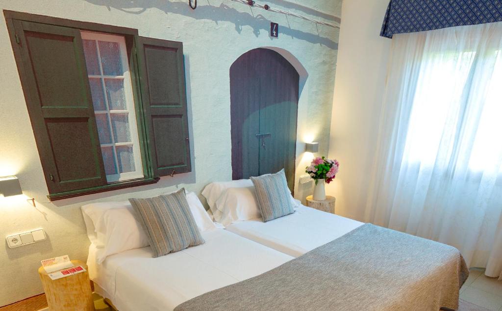 A bed or beds in a room at Es Baulo Petit Hotel