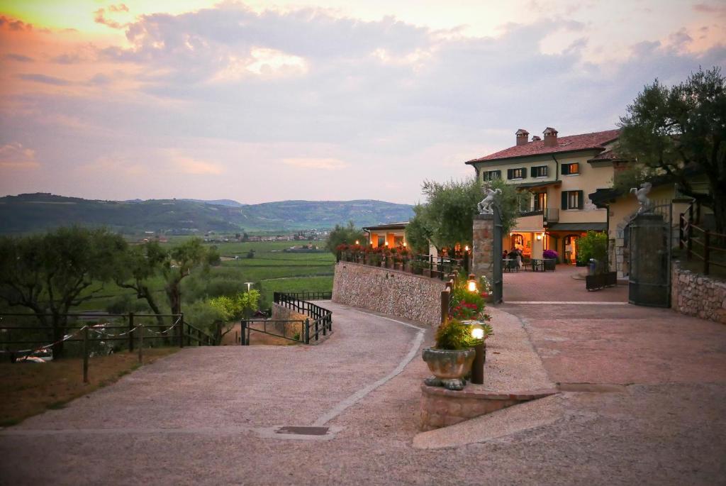 a walkway leading to a building with a house at Sporting Hotel San Felice in Illasi