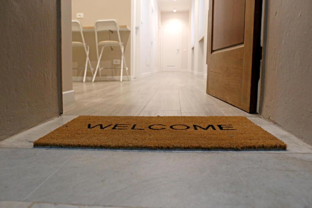 un tappetino di benvenuto sul pavimento in un corridoio di APP9 - rooms and apartments a Bergamo