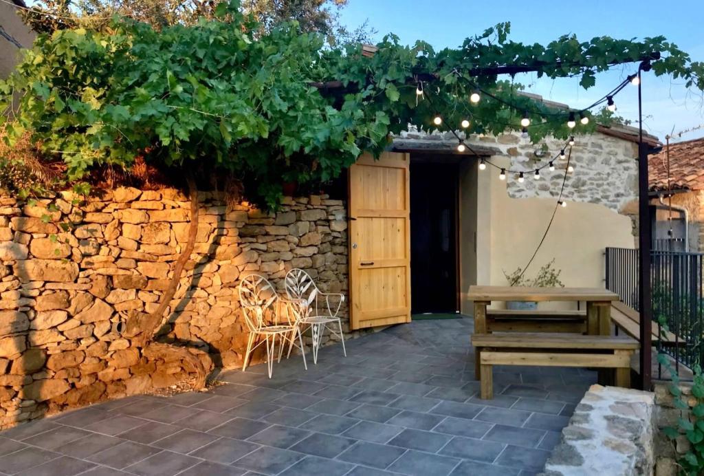 eine Terrasse mit einem Holztisch und einer Steinmauer in der Unterkunft Caseta de Magí in Ager