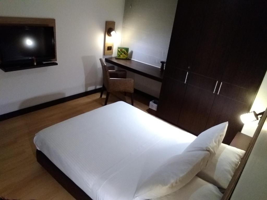 a bedroom with a bed and a desk and a television at Scala 68 in Bogotá