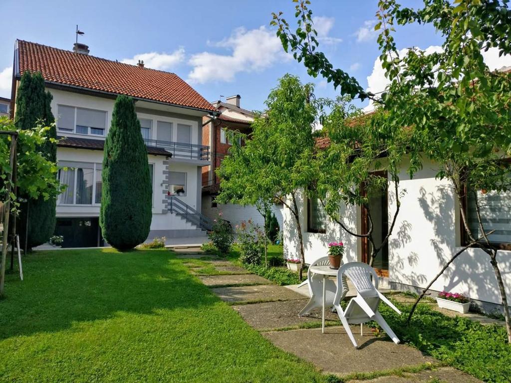 un jardín con 2 sillas y una casa en Garden Guesthouse, en Gjakove