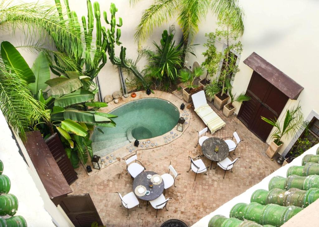 an overhead view of a pool with patio furniture and palm trees at Riad les Ammonites and Spa in Marrakesh