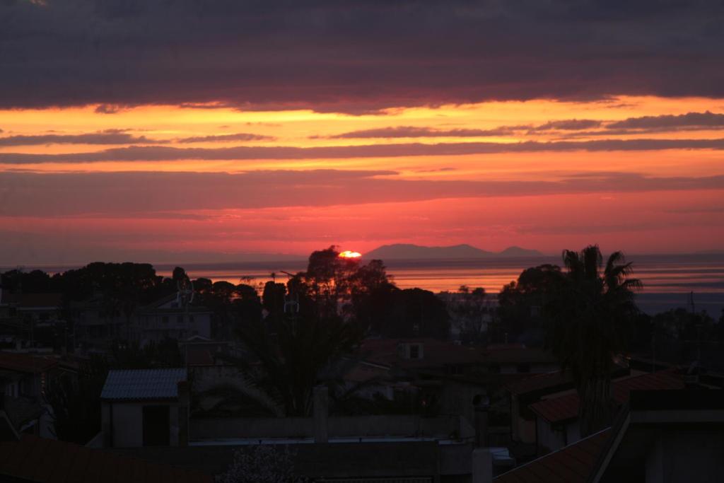 サンタ・ドメーニカにあるAppartamento panoramico Santa Domenicaの空の日が沈む都市の夕日