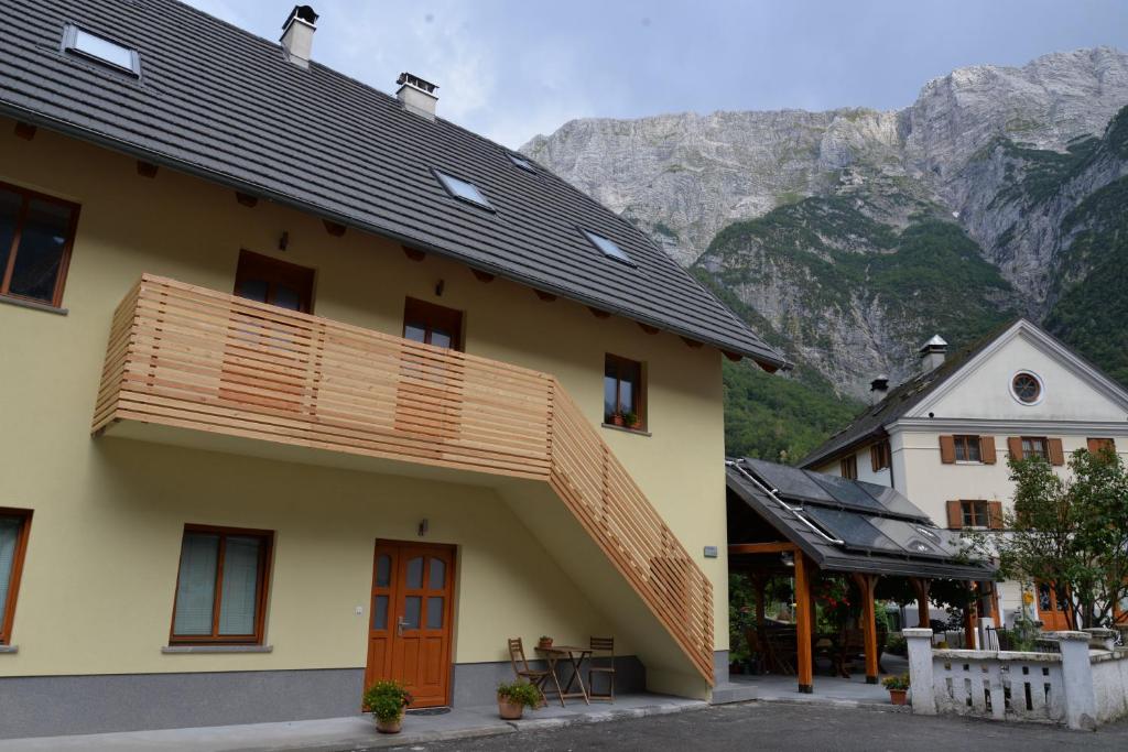 un edificio con balcón con montañas en el fondo en Hiša Urška, en Log pod Mangartom