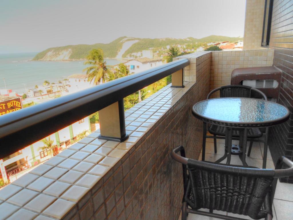 a balcony with a table and chairs and a view of the beach at Apartamento Maximum in Natal