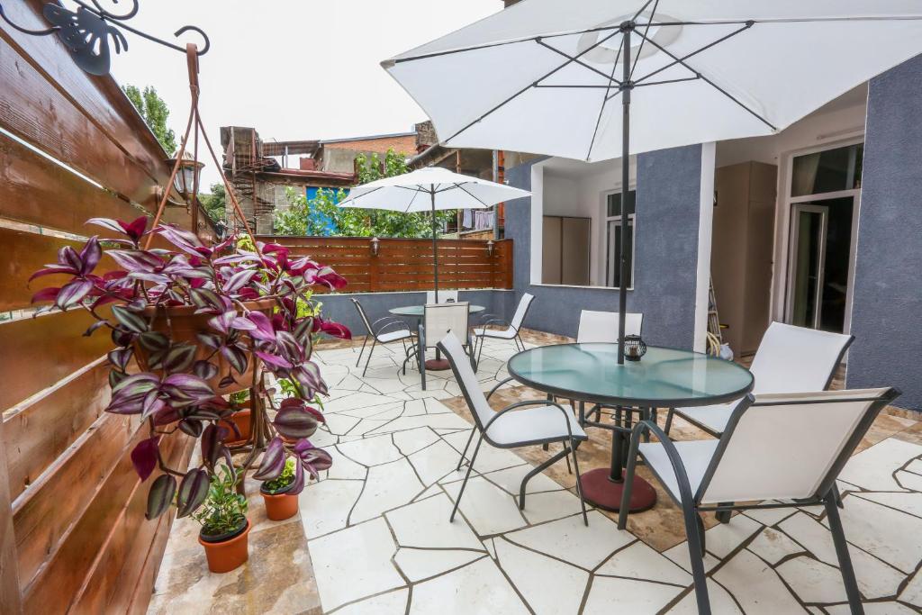 a patio with a table and chairs and an umbrella at Vortex - City Center in Tbilisi City