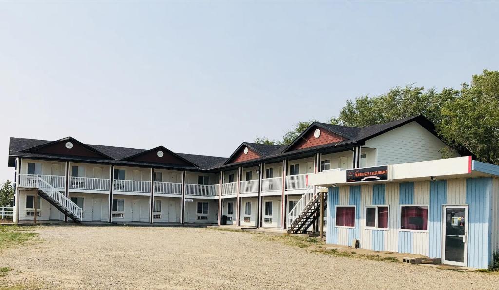 a large building with a lot of windows and roofs at Langham Motel in Langham