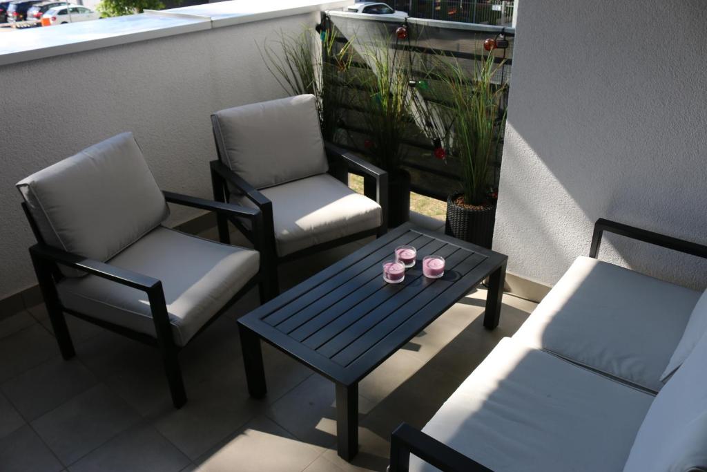 dwa krzesła i stół na balkonie w obiekcie Marynarski 43 w Pogorzelicy