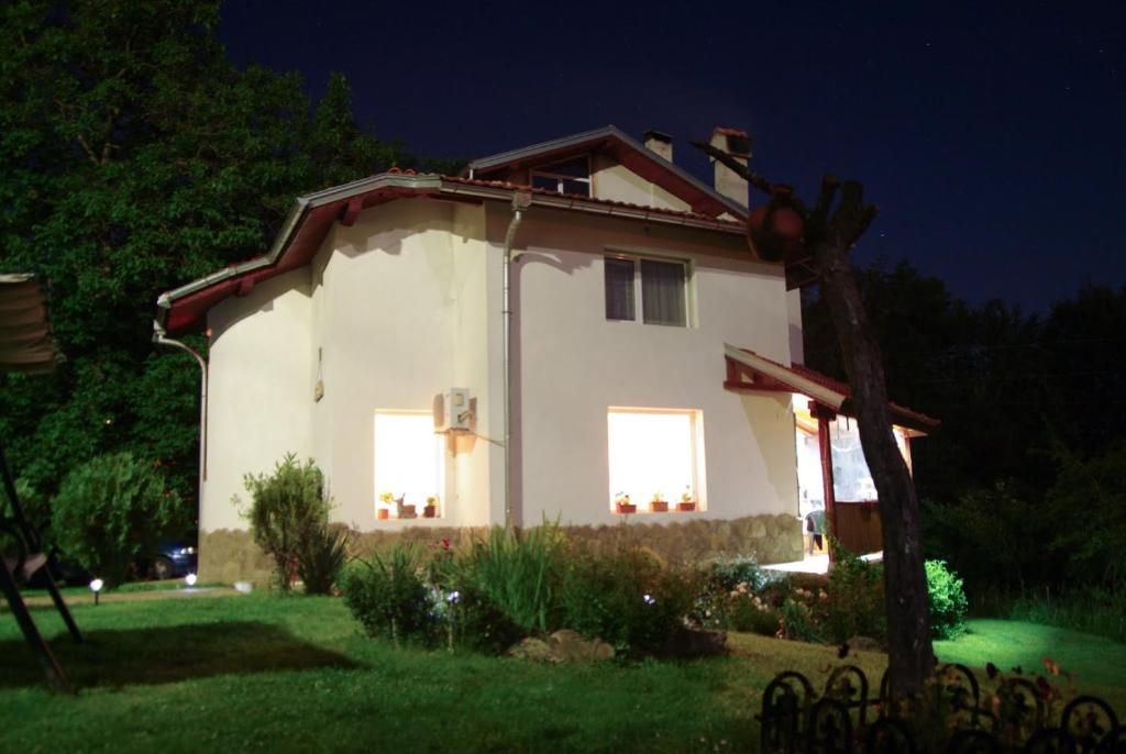 a small white house with two windows at night at Villa Diva in Apriltsi