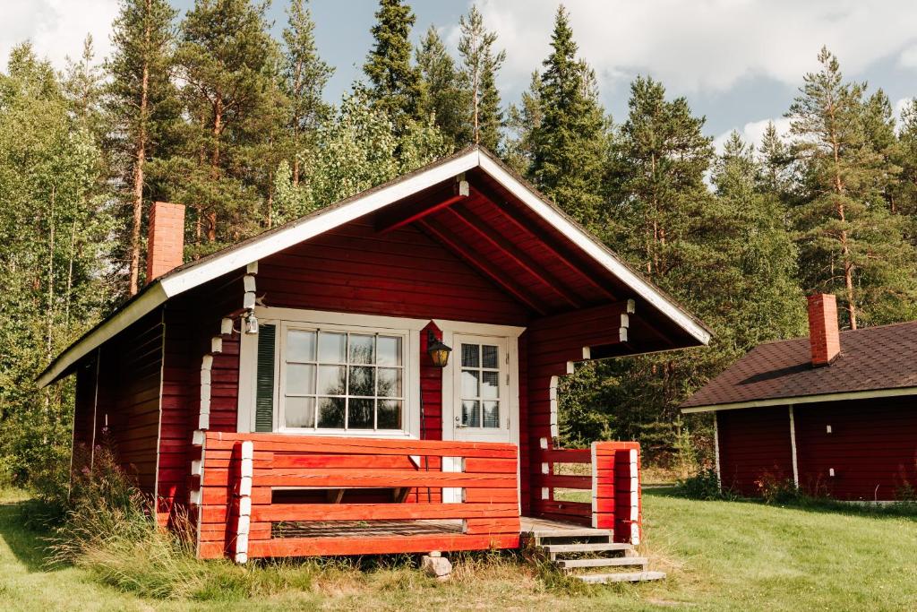 a red bench in front of a red house at Korvala log cabins in Korvala