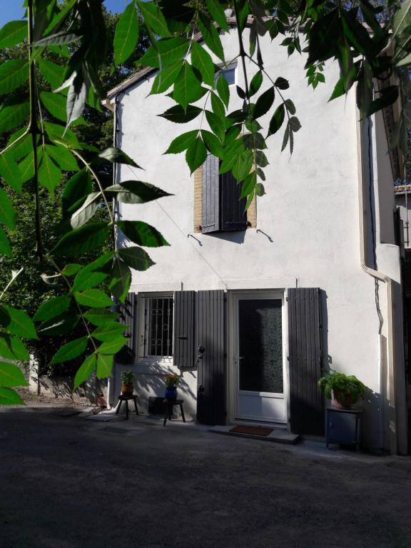 ein weißes Gebäude mit einer Tür und einem Fenster in der Unterkunft La Coulée Douce - Chez Antoine in Castelnaudary