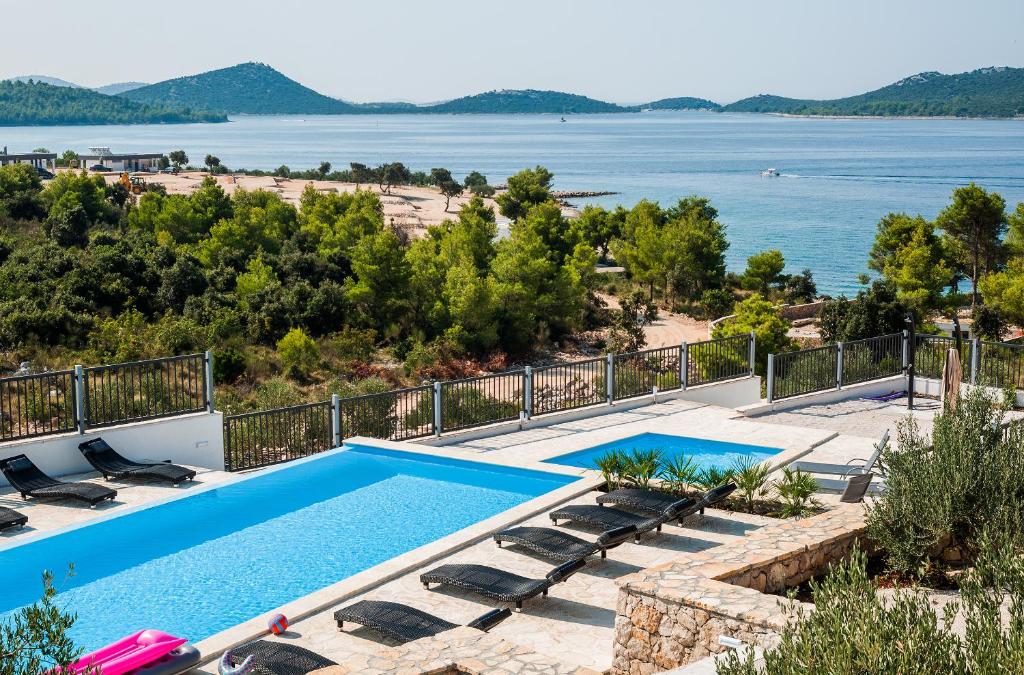 a villa with a swimming pool and a view of the water at Camp Panorama with pool in Drage