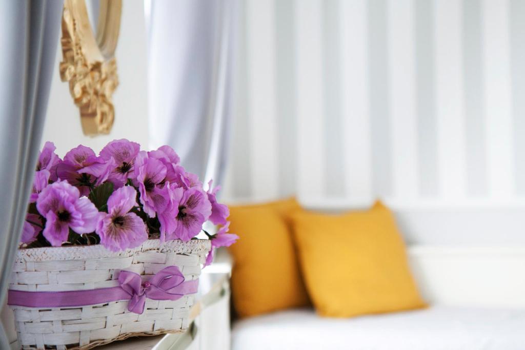 una cesta llena de flores púrpuras sentada en una mesa en Apartament LOFT Glamour EC1, en Łódź