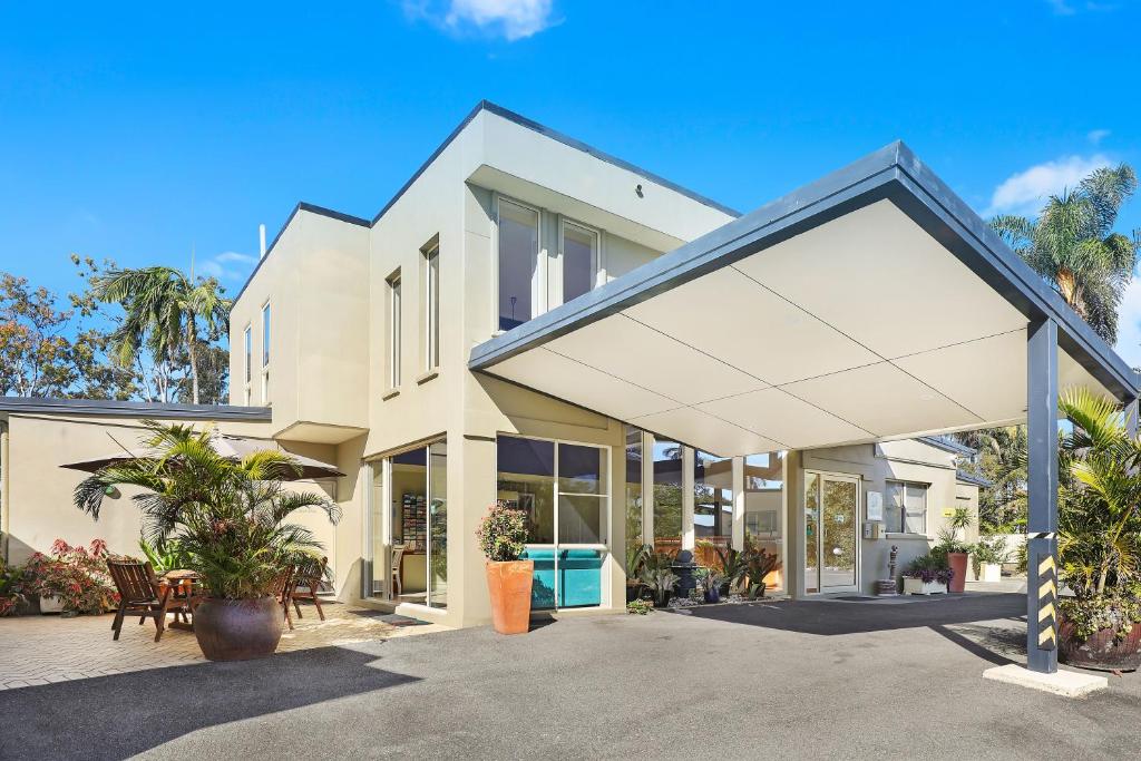 a large white house with awning at Caboolture Riverlakes Boutique Motel in Caboolture