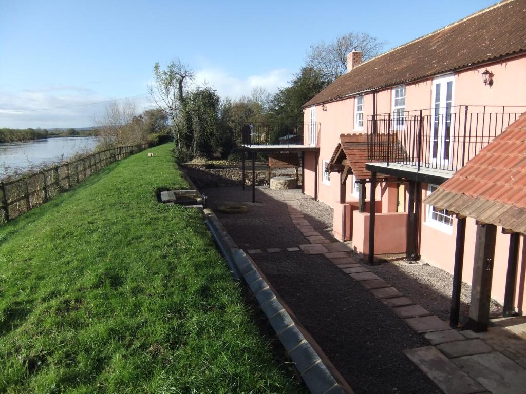 una pasarela entre dos edificios junto a un río en Pershbrook Cottage & Garden, en Oakle Street