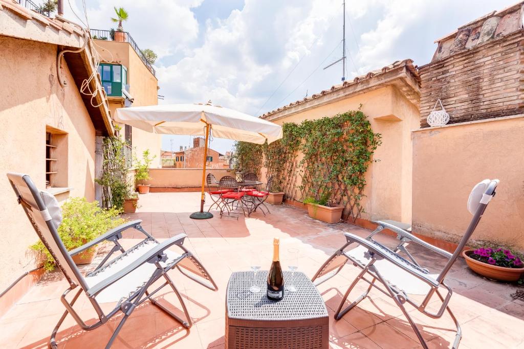 a patio with a table and chairs and an umbrella at Romantic house with terrace in Rome