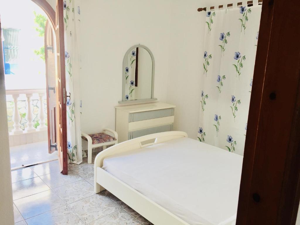 Dormitorio pequeño con cama y espejo en SEASIDE apartment, en Koroni