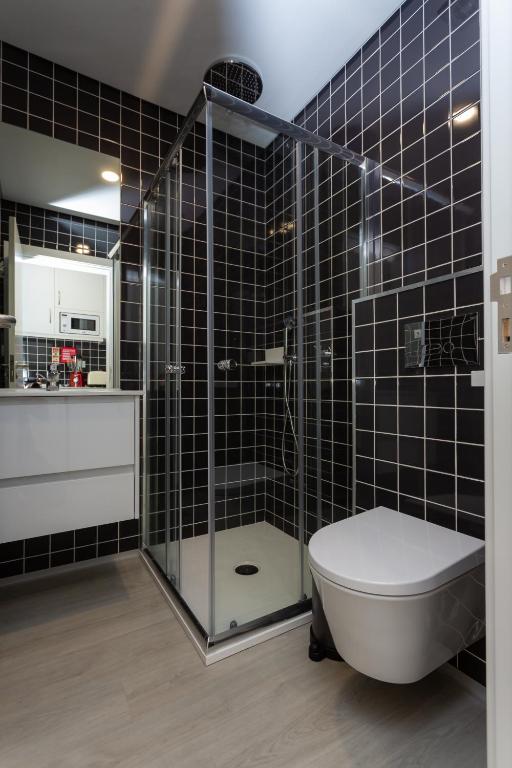 a bathroom with a glass shower and a toilet at Chic Studios in Parede