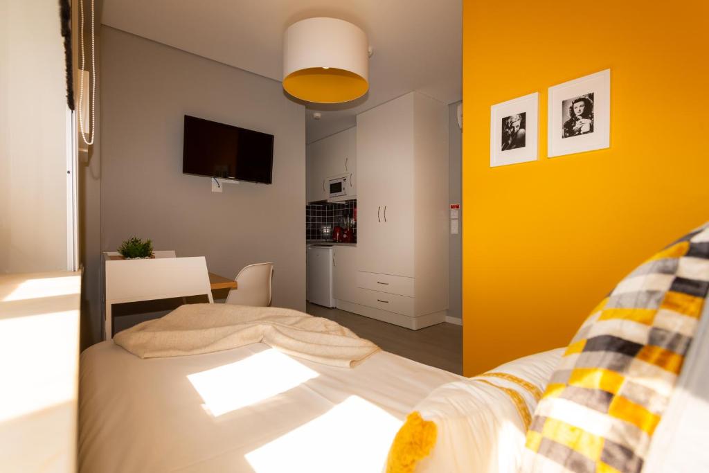 a bedroom with a bed and a yellow wall at Chic Studios in Parede