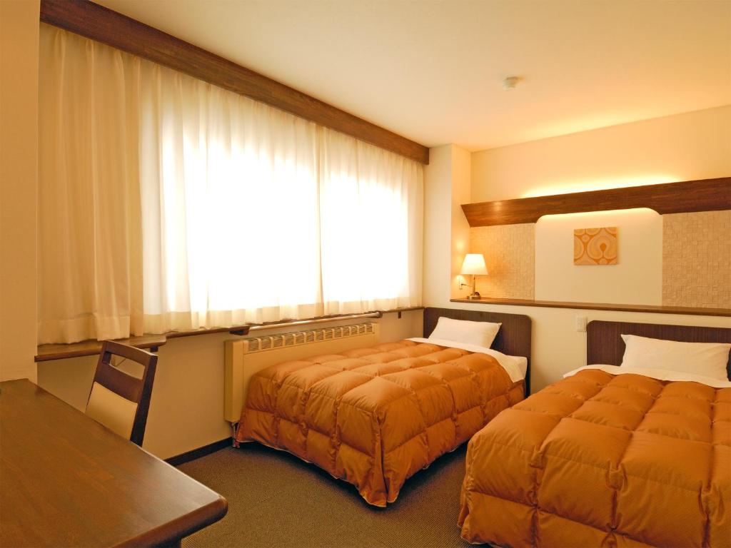 Postel nebo postele na pokoji v ubytování Shiga Kogen Olympic Hotel