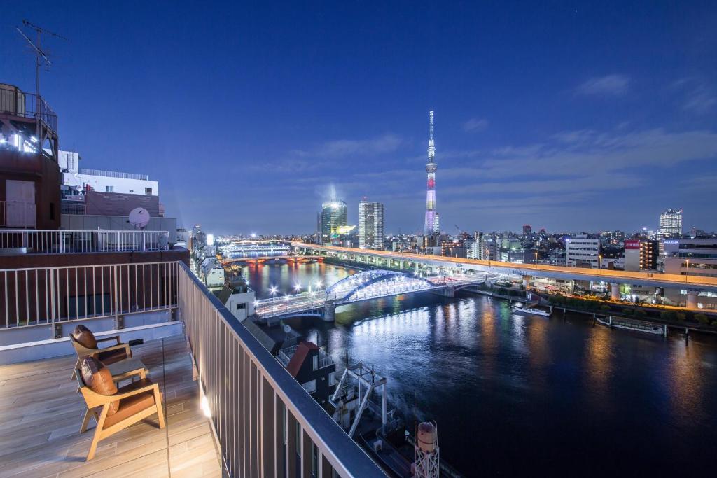 uma varanda com vista para um rio à noite em HOTEL AMANEK Asakusa Ekimae em Tóquio