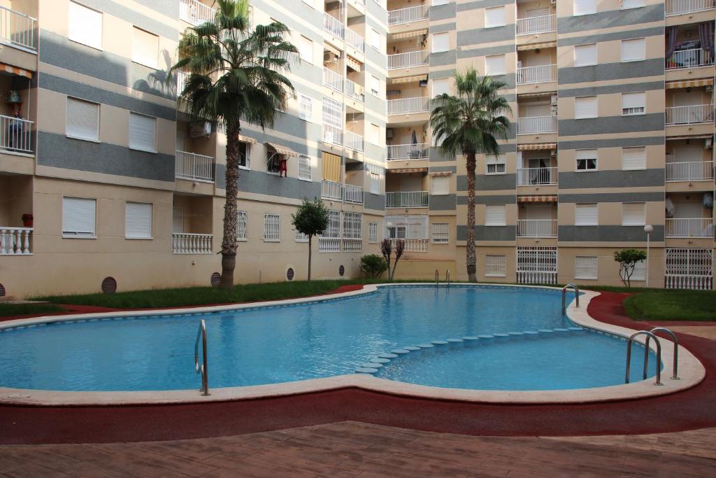 a swimming pool in front of a large apartment building at Torreviejagases in Torrevieja