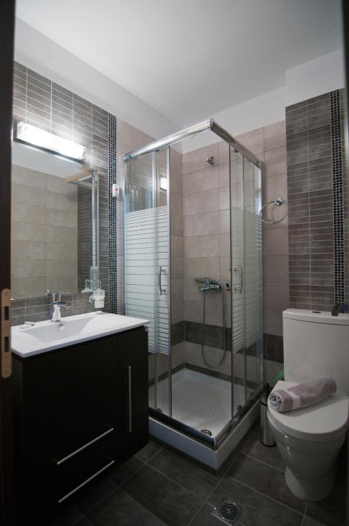 a bathroom with a shower and a sink and a toilet at Riviera Perdika Hotel in Perdika