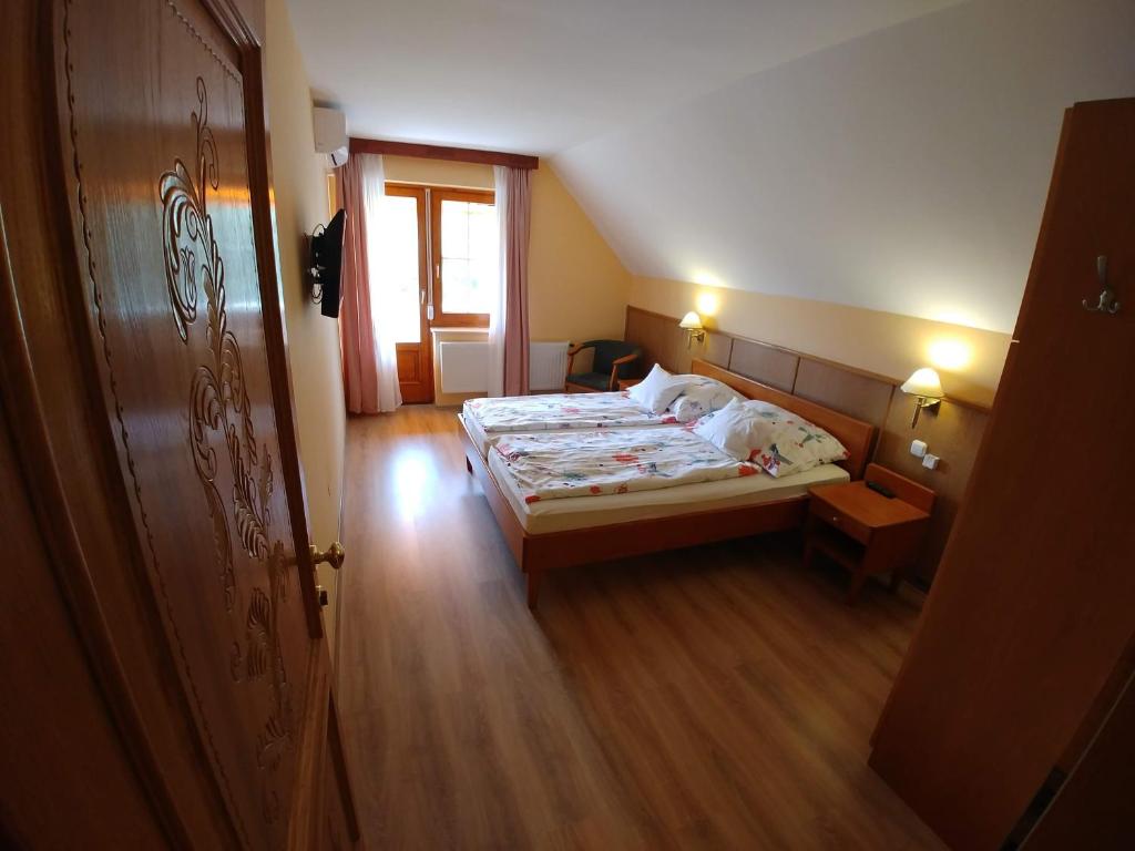 a bedroom with two beds and a window at Zöld sziget Apartmanház in Gyenesdiás