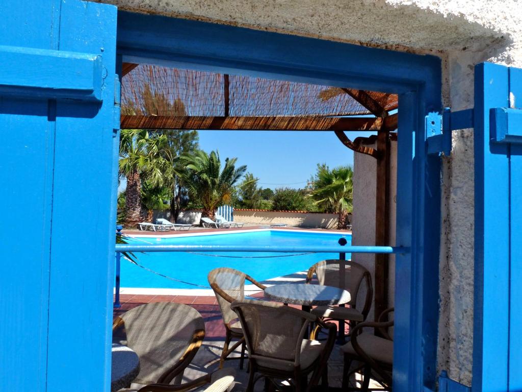 a blue door leading to a patio with a table and chairs at Orama Hotel in Sígrion