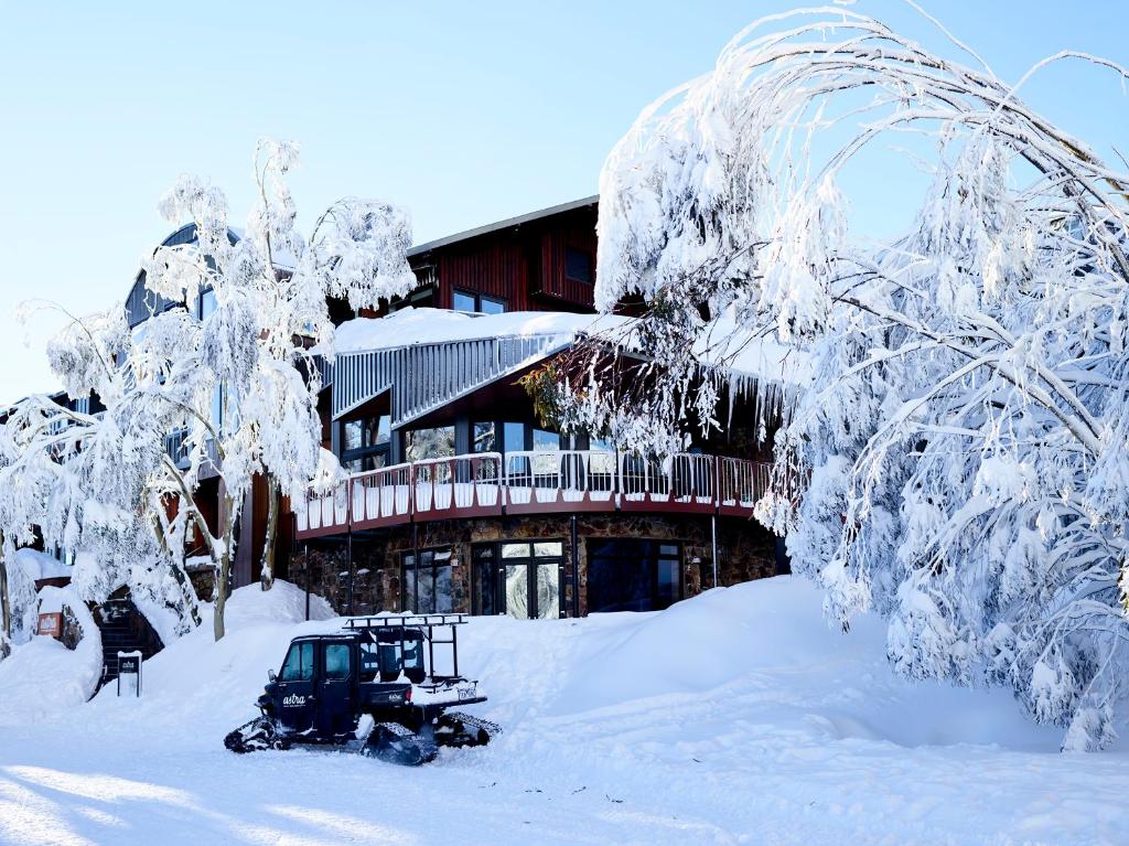 un edificio ricoperto di neve con un bulldozer di Astra Falls Creek a Falls Creek