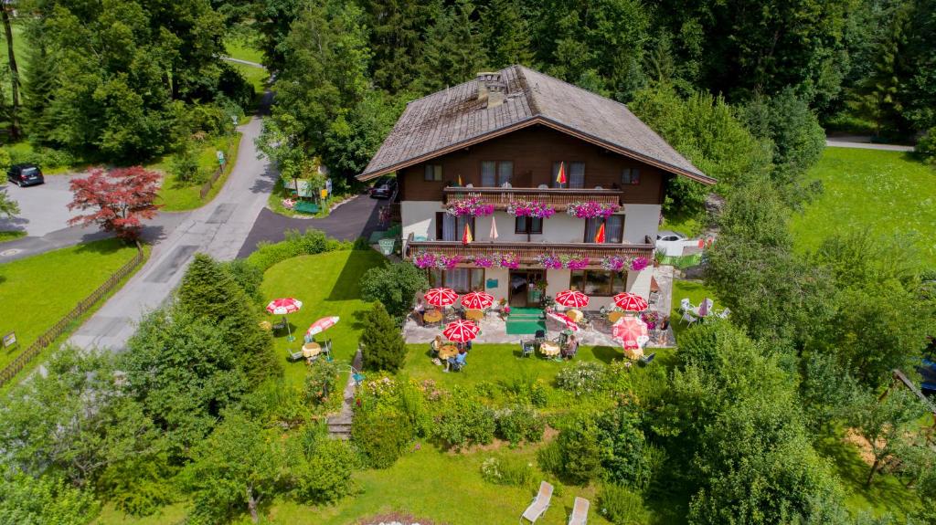 an aerial view of a house with umbrellas in the yard at Pension Wildental in Sankt Martin bei Lofer