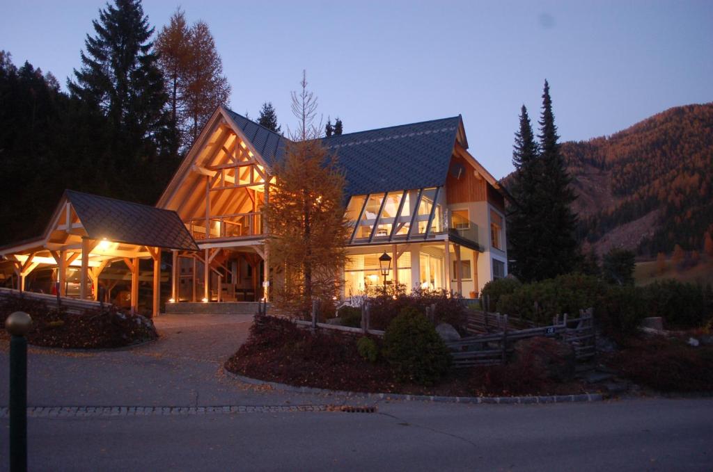 ein großes Haus mit einem großen Gebäude am Abend in der Unterkunft Apartment Bad Kleinkirchheim in Bad Kleinkirchheim