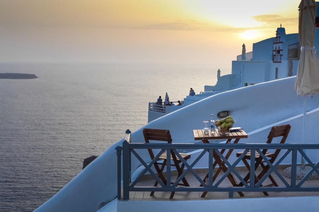 een tafel aan de zijkant van een cruiseschip met uitzicht op de oceaan bij White Side Suites in Oia