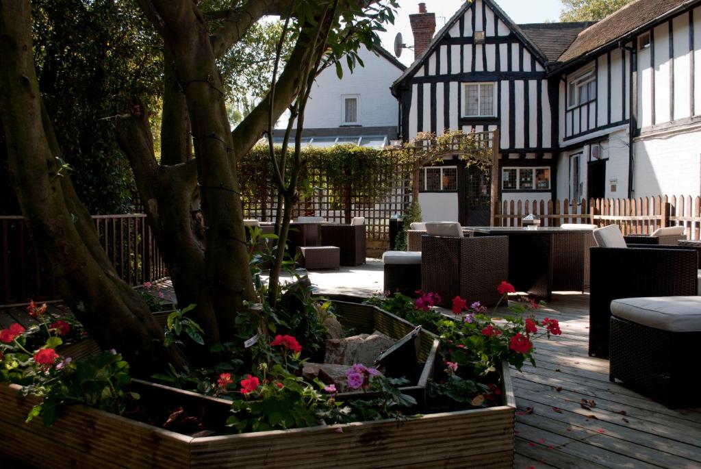 einen Garten vor einem schwarz-weißen Gebäude in der Unterkunft The Tudor Hotel in Harrow