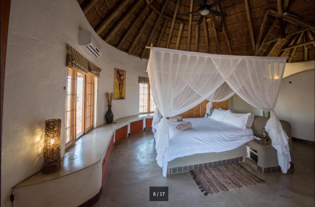 a bedroom with a bed with a mosquito net at Villa Leopards Lookout in Marloth Park
