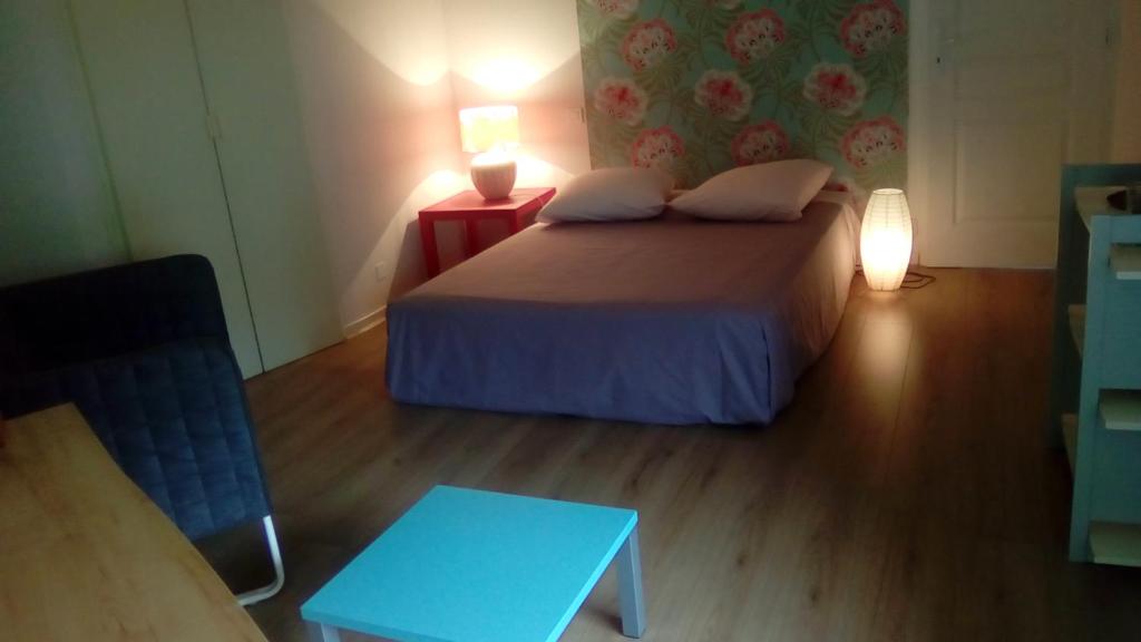 ein kleines Schlafzimmer mit einem Bett und einem Tisch in der Unterkunft Les Barrerres in Hontanx