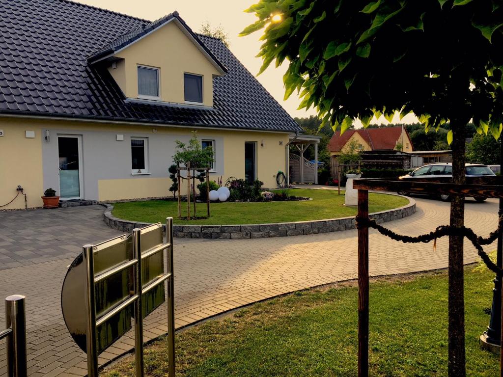 a house with a fence in front of a yard at Ferienwohnung „Kranich“ in Mirow