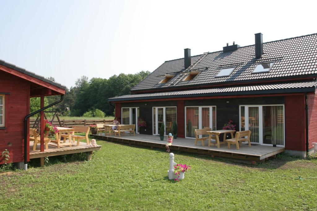 a house with a deck with a table and chairs at Love Island Guesthouse in Druskininkai