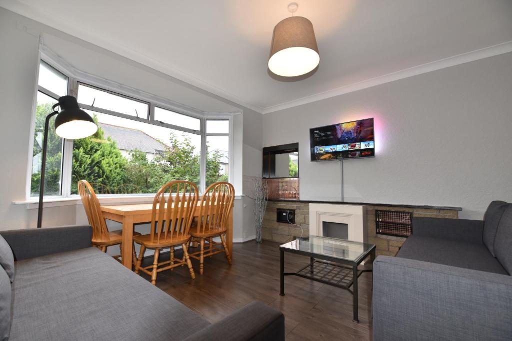 - un salon avec un canapé, une table et des chaises dans l'établissement Sighthill 3 Bedrooms with Private Garden, à Édimbourg