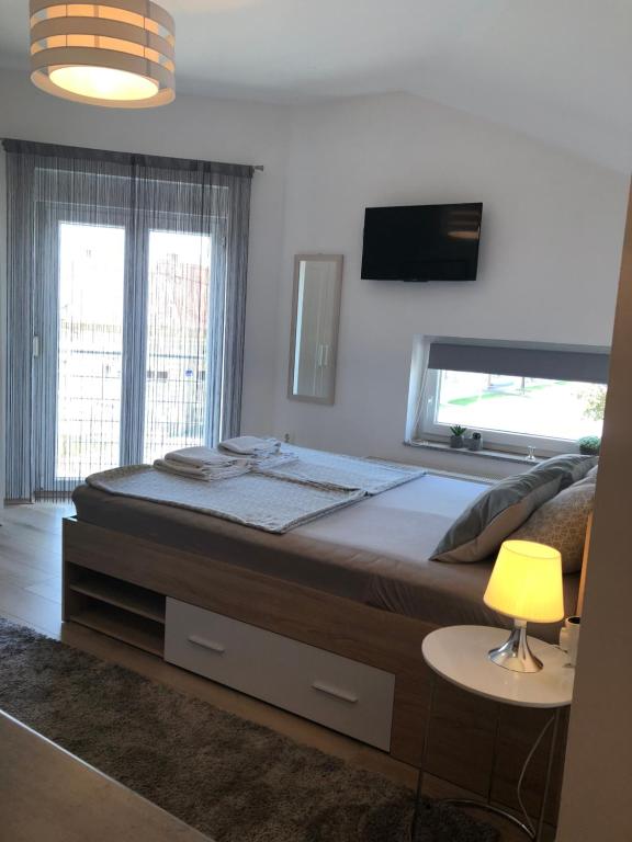 a bedroom with a large bed with a tv on the wall at Luma 2 in Osijek