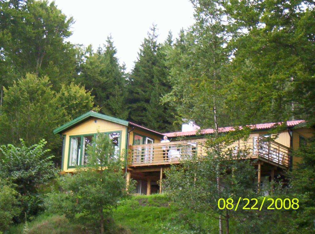 una casa grande con terraza en el bosque en Semestervilla vid sjö en Arkelstorp