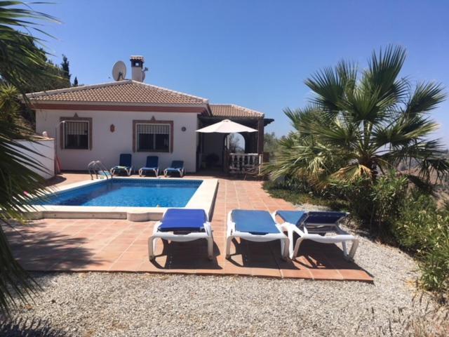 - une piscine avec 2 chaises et une maison dans l'établissement Villa Competa, à Cómpeta