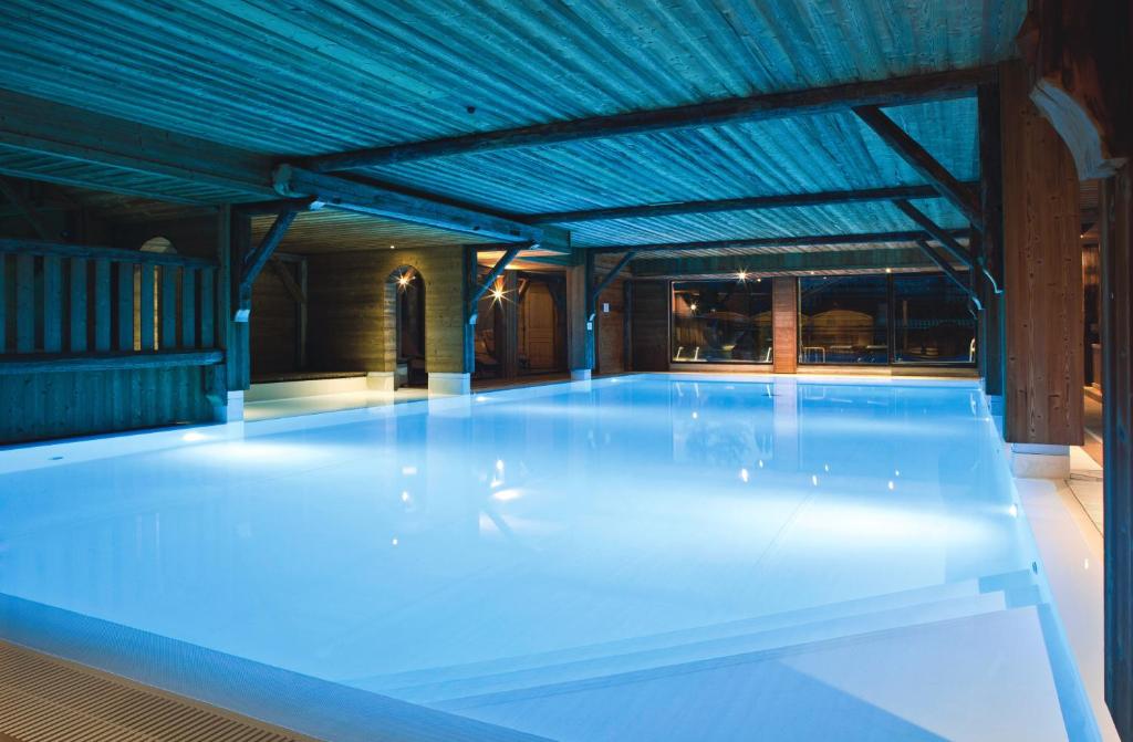 a swimming pool with a pool table and chairs at Chalet-Hôtel La Marmotte, La Tapiaz & SPA, The Originals Relais (Hotel-Chalet de Tradition) in Les Gets