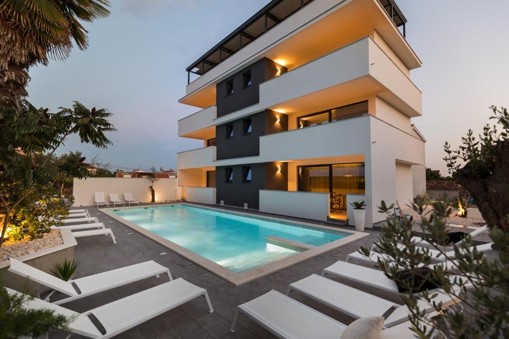 a villa with a swimming pool in front of a house at Mirabilis Residence in Zadar