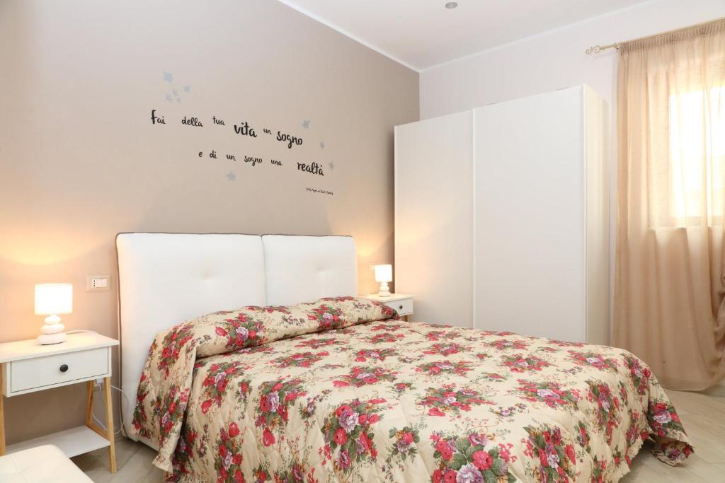 een slaapkamer met een bed met een bloemenbed bij La Casetta del Borgo Cefalù in Cefalù