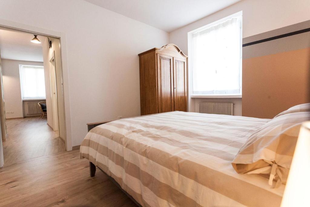 um quarto com uma cama grande e 2 janelas em Casa "Le Mura" 70mq em Riva del Garda