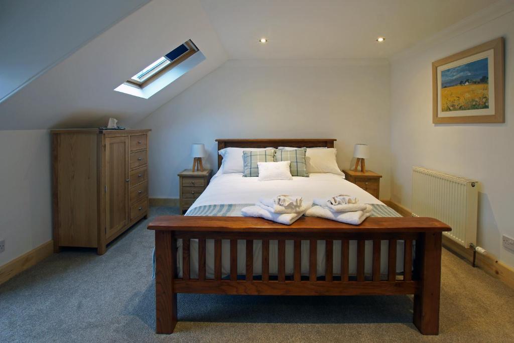 a bedroom with a bed with two towels on it at Cameron Cottage in Inverkip