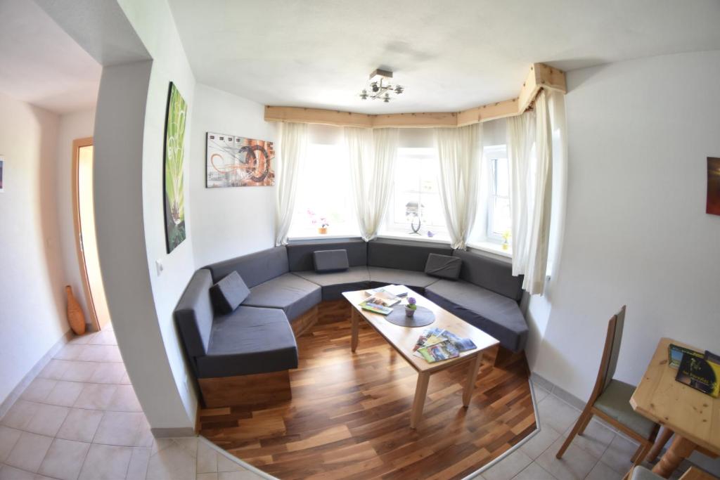ein Wohnzimmer mit einem Sofa und einem Tisch in der Unterkunft Appartement Sabrina in Haus im Ennstal